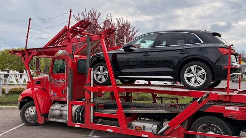 Vehicle being loaded at a Houston-area dealership for auto transport