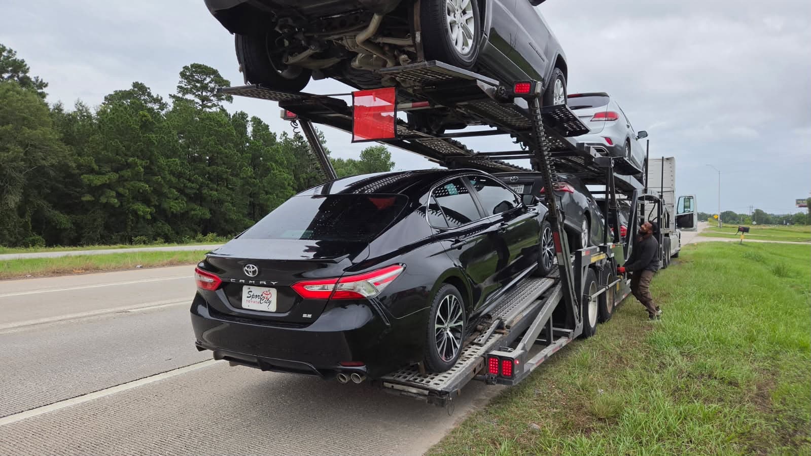 Toyota Camry loaded on an open auto transport carrier