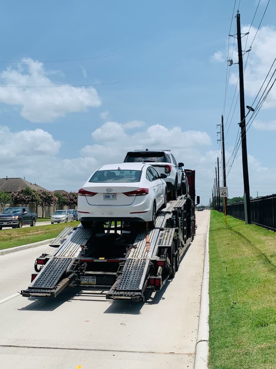 Hyundai Elantra secured on an open auto transport carrier ahead of departure from Katy, TX