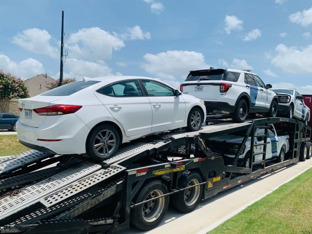 White Hyundai Elantra loaded on an open auto transport carrier in Katy, TX