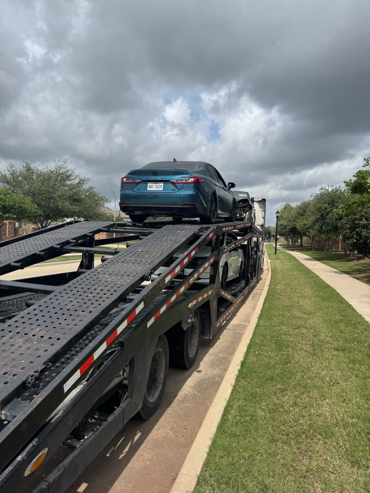 Toyota Camry loaded on an open auto transport carrier