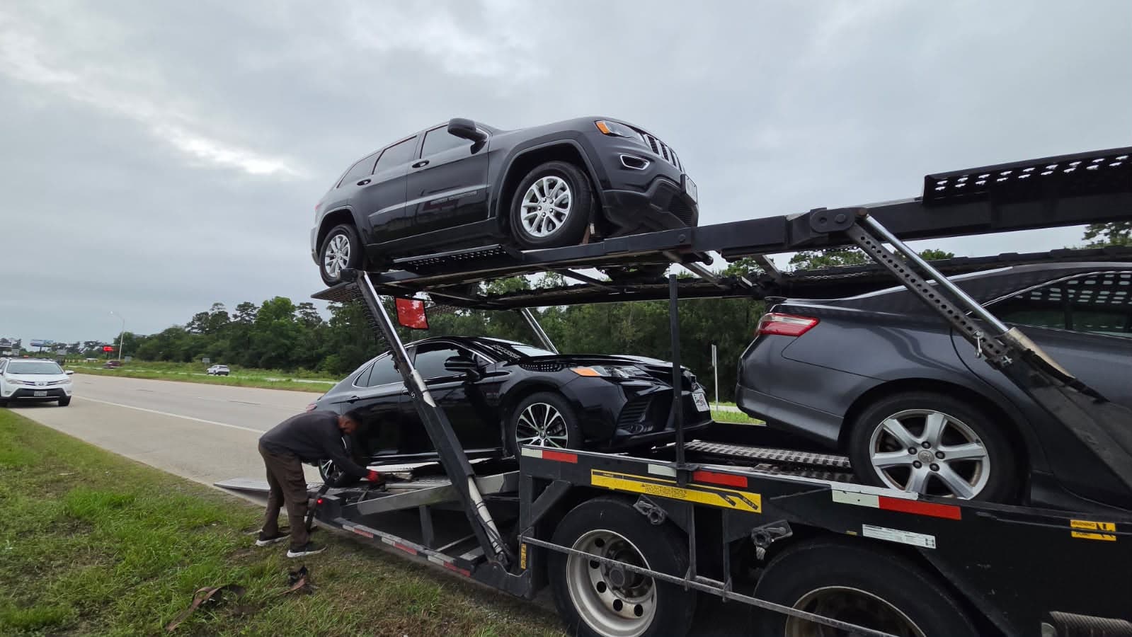 Vehicles being loaded onto an open auto transport carrier in Conroe, TX