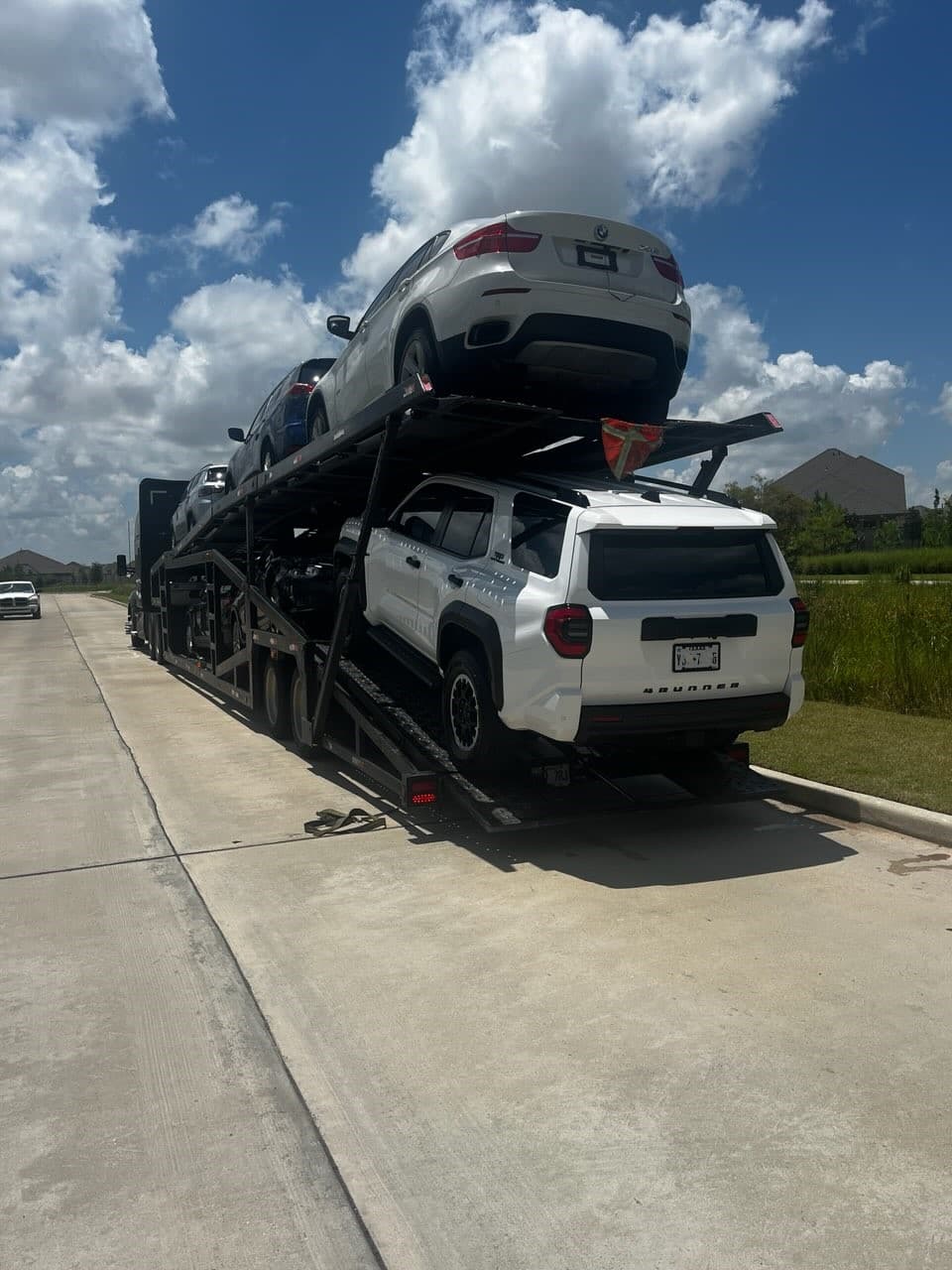 2025 Toyota 4Runner secured on an open auto transport carrier ahead of departure from Cypress, TX