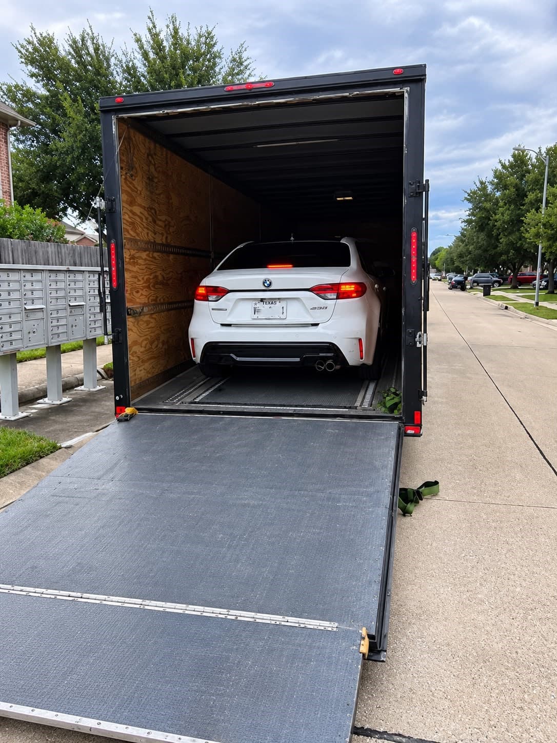 Low-clearance Toyota Corolla with approximately 4 inches of clearance at an enclosed carrier loading area
